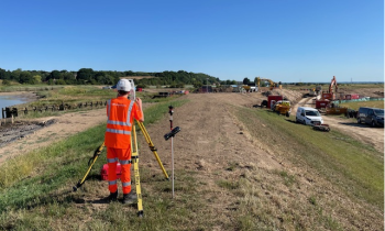 Student stood on a grassy bank on site.