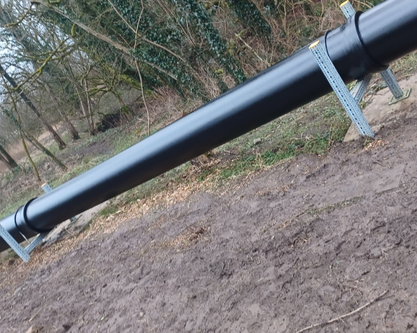 Picture of a black pipe in the woods.