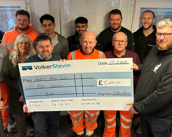 People stood around a giant check.