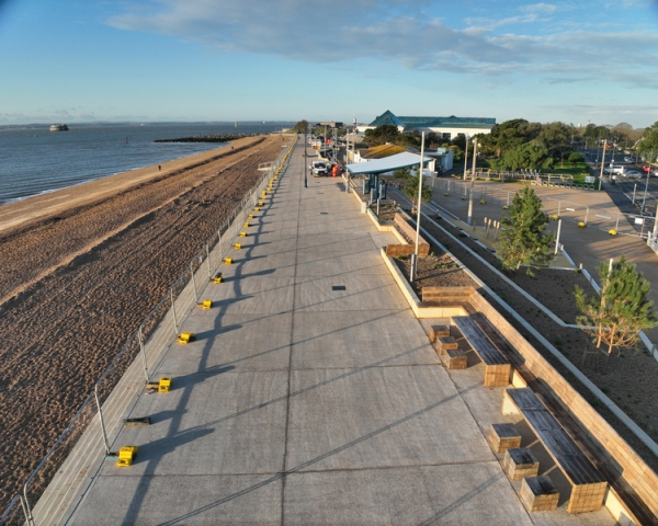 Promenade with beach and see to the leaf of the photo, blue sky