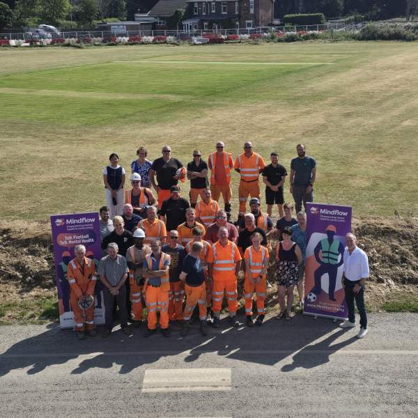 People stood outside next to a banner for a mental health event.