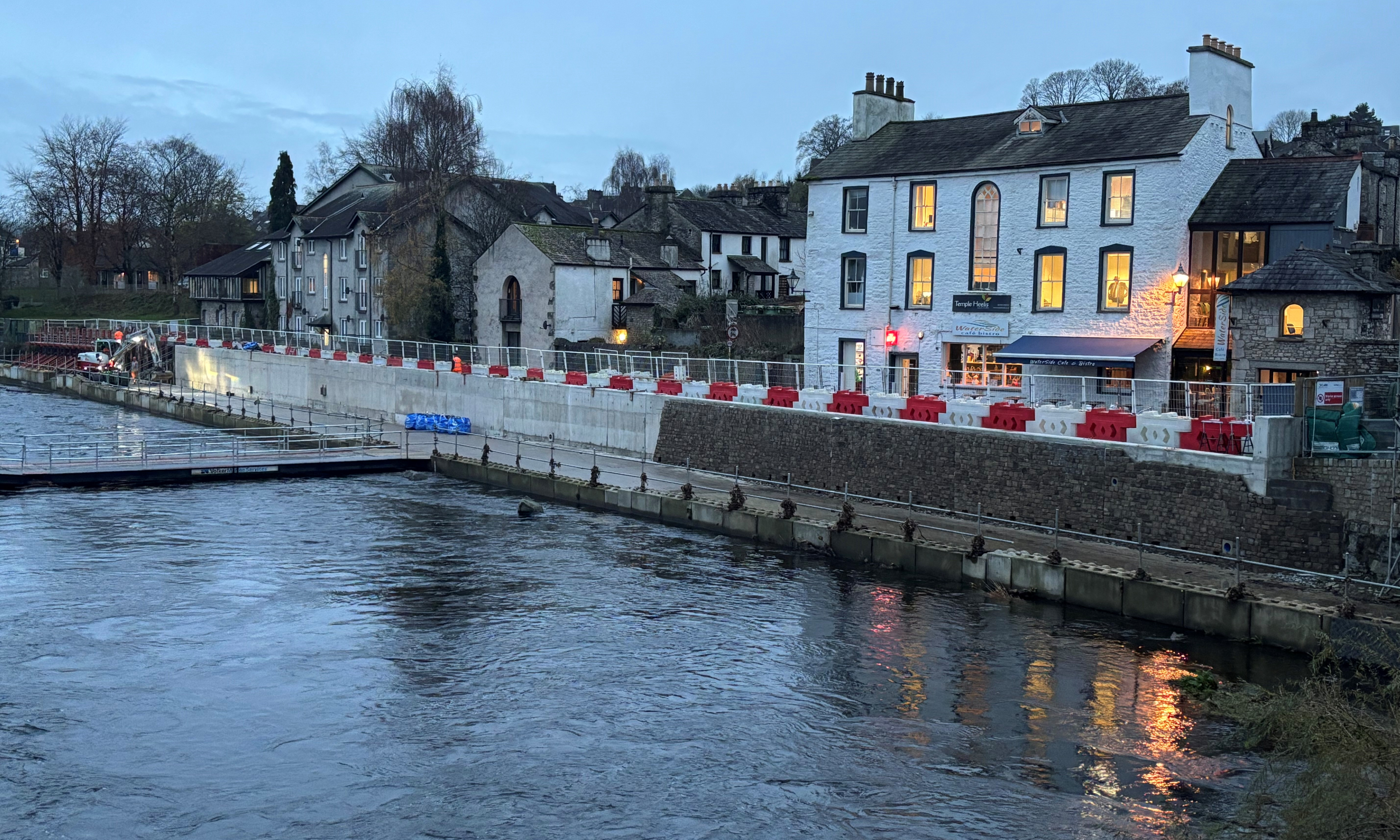 Kendal Flood Risk Management Scheme flood wall along a river at dusk
