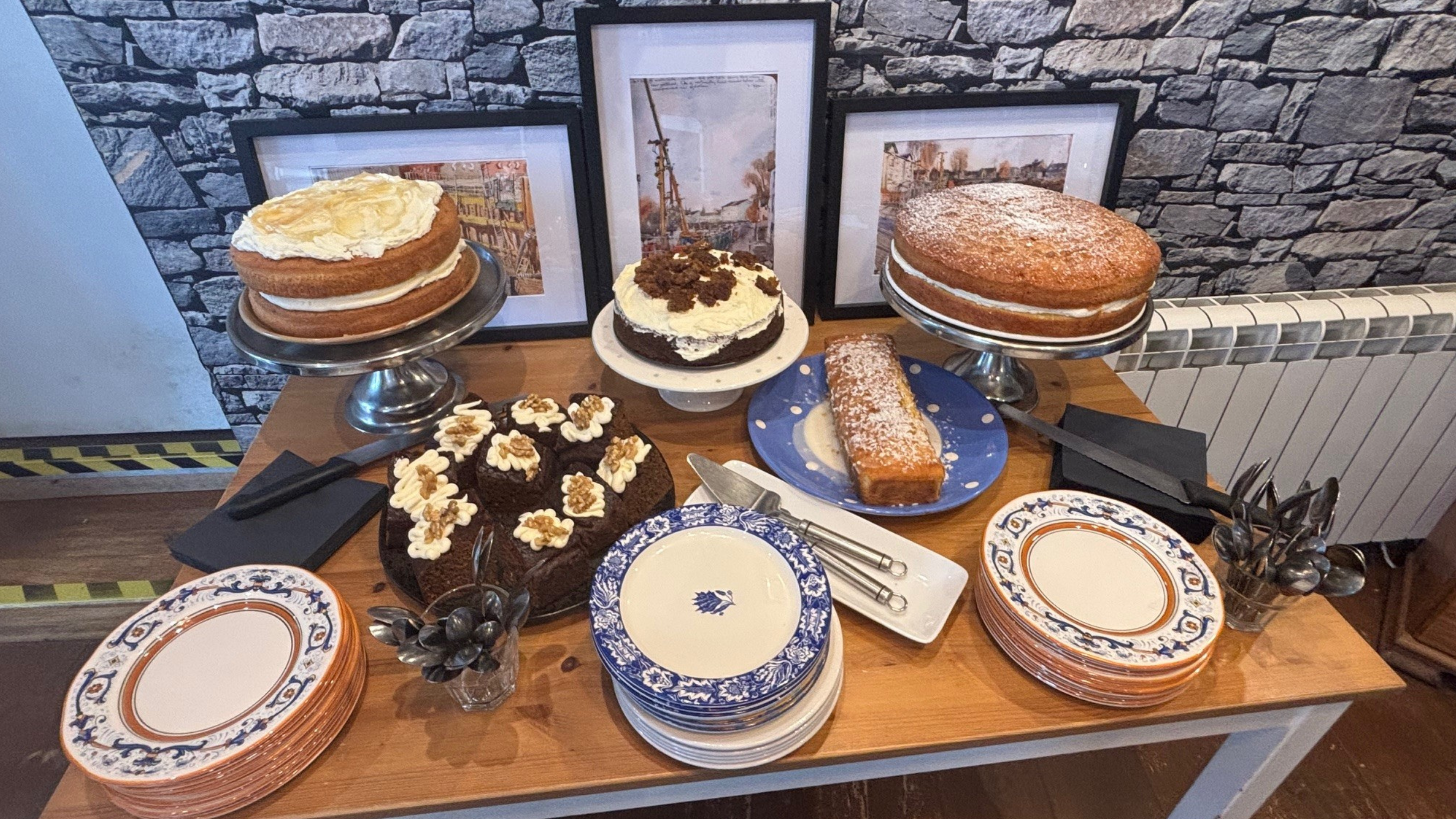 Table with five large cakes and serving plates